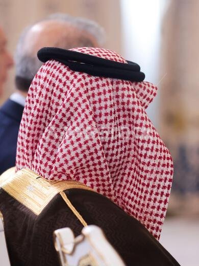 تفاصيل ذات عمق مجال ضحل مع رجل في الجمهور يرتدي غترة إسلامية، شماغ، كوفية، وهو وشاح قطني مربع مثبت بحبل أسود يسمى