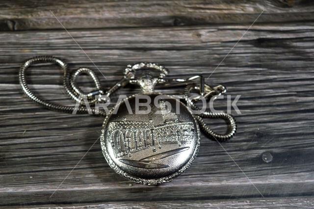 The prophet mosque in Medina on a silver colored pocket watch, pocket watch is a portable timepiece designed to be carried in a pocket, typically with
