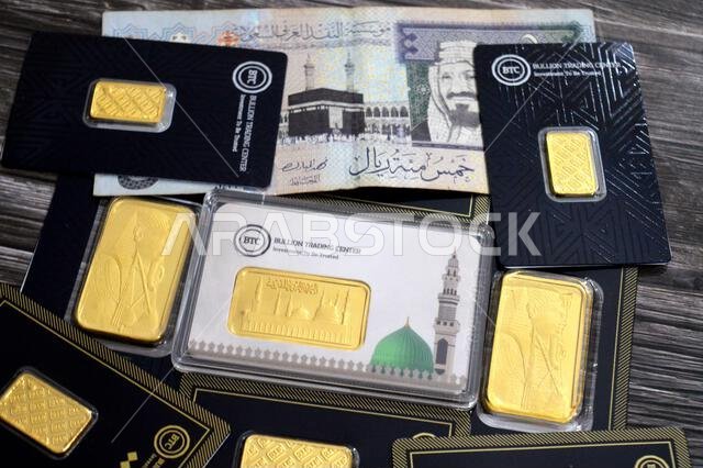 القاهرة، مصر، 6 فبراير 2026: ريال سعودي وسبائك ذهب أصفر عيار 24 قيراطًا في مركز تداول سبائك البيتكوين. المسجد النبوي في المتوسط.