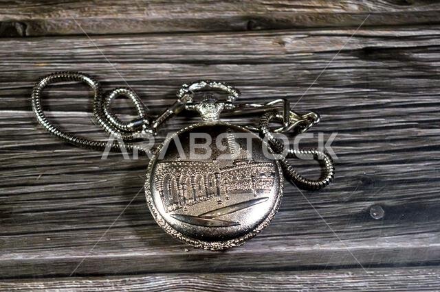 The prophet mosque in Medina on a silver colored pocket watch, pocket watch is a portable timepiece designed to be carried in a pocket, typically with