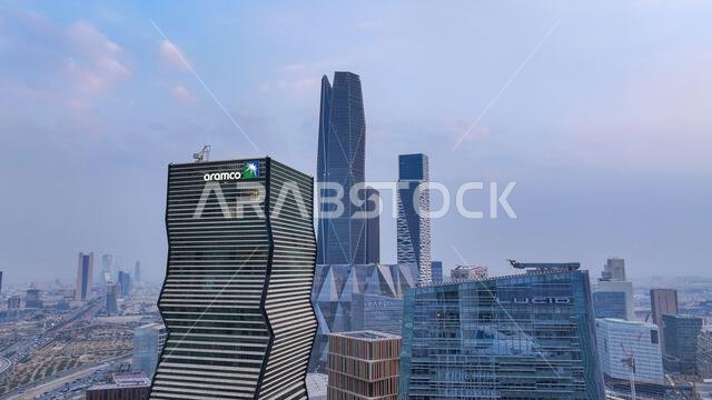 Aramco Tower with KAFD skyline and Riyadh cityscape in daytime, showing modern skyscrapers and urban development in Saudi Arabia.