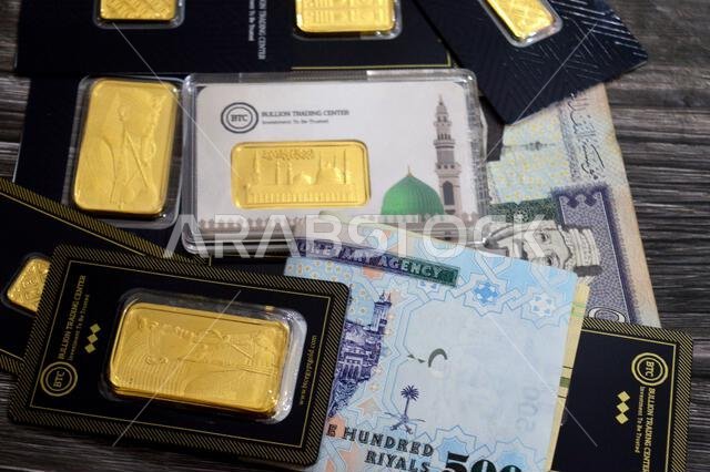 القاهرة، مصر، 6 فبراير 2026: ريال سعودي وسبائك ذهب أصفر عيار 24 قيراطًا في مركز تداول سبائك البيتكوين. المسجد النبوي في المتوسط.