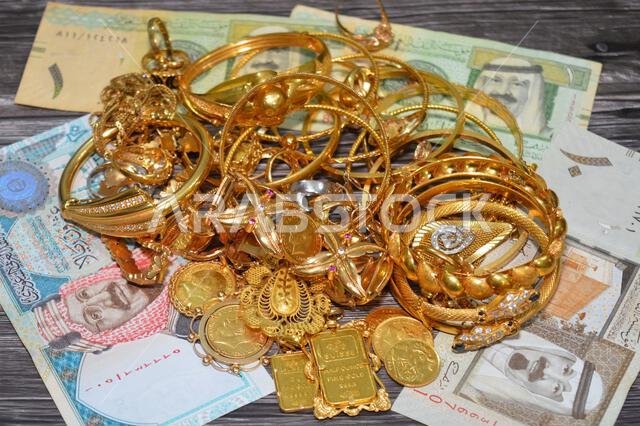 القاهرة، مصر، 9 يناير 2026: عملات الريال السعودي (SAR) وكومة من الذهب على ميزان رقمي بالجرام، وسبائك الذهب، والجنيهات الإسترلينية، والأساور، و...