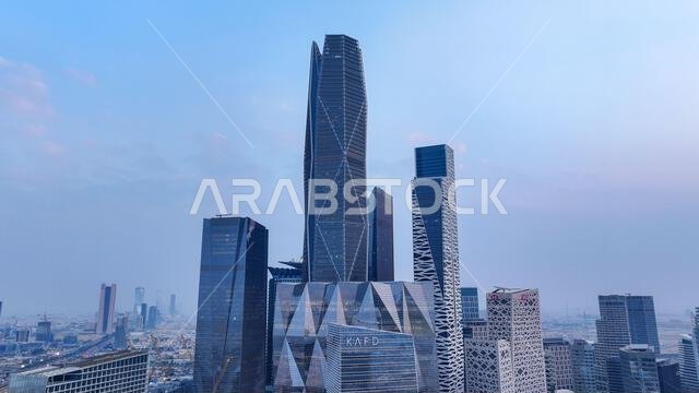 برج أرامكو مع أفق مركز الملك عبد العزيز للطيران المدني وأفق مدينة الرياض في النهار، مما يُظهر ناطحات السحاب الحديثة والتطور العمراني في المملكة العربية السعودية.