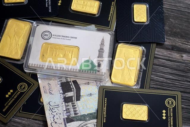 القاهرة، مصر، 6 فبراير 2026: ريال سعودي وسبائك ذهب أصفر عيار 24 قيراطًا في مركز تداول سبائك البيتكوين. المسجد النبوي في المتوسط.