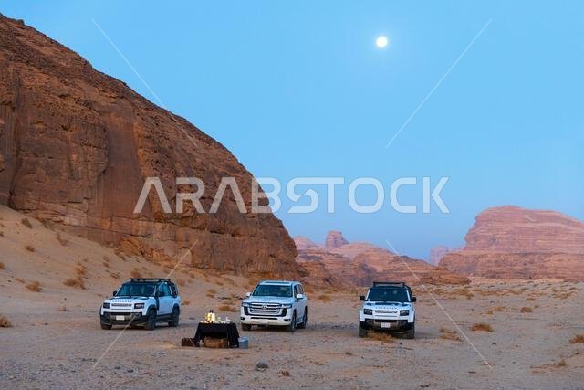 Three white off-road vehicles of Hero Balloon Flights Saud parked in the desert near AlUla, Saudi Arabia