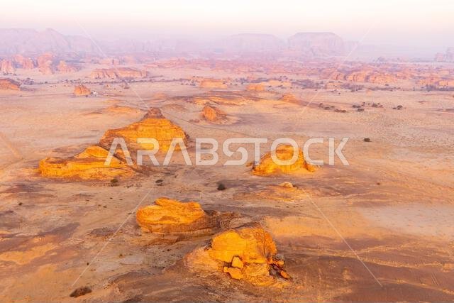 منظر جوي لجبل الحِجر والمناطق المحيطة به عند الفجر من منطاد هوائي ساخن بالقرب من العلا، المملكة العربية السعودية