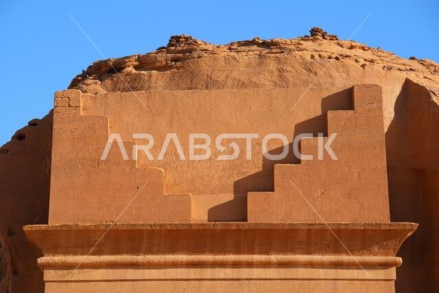 Geometric stepped merlons carved into the sandstone on the Tomb of Lihyan son of Kuza in Hegra, an ancient nabataean city in the desert of Saudi Arabi
