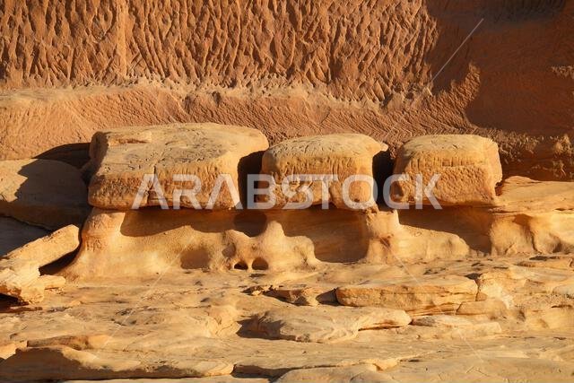 Graves at the base of the Tomb of Lihyan son of Kuza in Hegra, an ancient nabataean city in the desert of Saudi Arabia