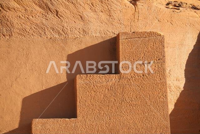 Geometric stepped merlons carved into the sandstone on the Tomb of Lihyan son of Kuza in Hegra, an ancient nabataean city in the desert of Saudi Arabi