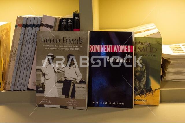 صورة مقربة لكتب باللغة الإنجليزية تتناول تاريخ وثقافة المملكة العربية السعودية، وتضم عناوين مثل "أصدقاء إلى الأبد" و"نساء بارزات". صورة مقربة لكتب باللغة الإنجليزية تتناول تاريخ وثقافة المملكة العربية السعودية، وتضم عناوين مثل "أصدقاء إلى الأبد" و"نساء بارزات".