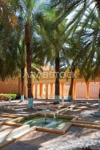 نافورة مياه تقليدية وبستان نخيل في قصر المربع التاريخي بالرياض، المملكة العربية السعودية