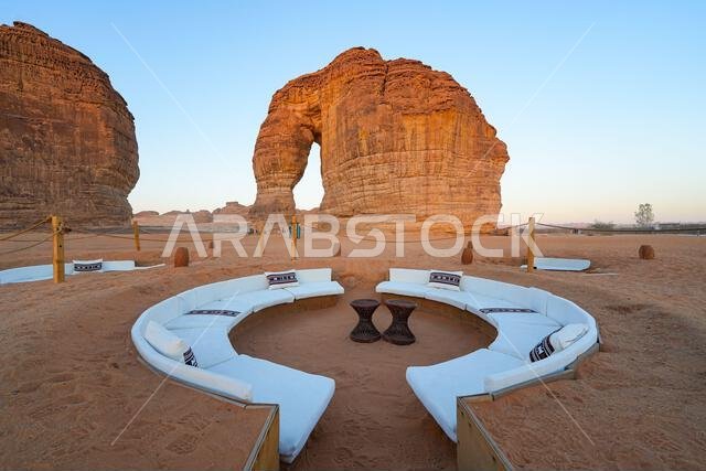 صالة صحراوية فاخرة عند سفح جبل الفيل (صخرة الفيل) عند غروب الشمس في صحراء العلا، المملكة العربية السعودية