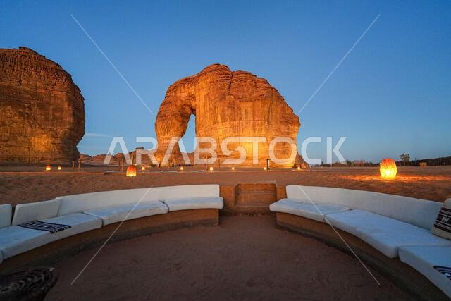 Luxury desert lounge at the foot of Elephant Rock (Jabal Al-Fil) at dusk in the desert of AlUla, Saudi Arabia