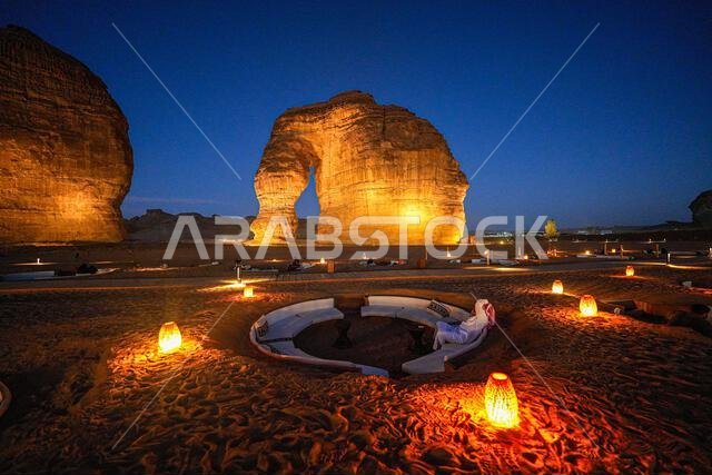 Luxury desert lounge at the foot of Elephant Rock (Jabal Al-Fil) at dusk in the desert of AlUla, Saudi Arabia