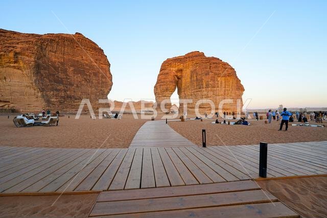 ممر خشبي يؤدي إلى صخرة الفيل الشهيرة في العلا عند غروب الشمس، المملكة العربية السعودية