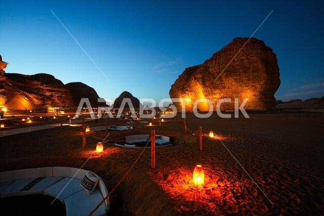 Luxury desert lounge at the foot of Elephant Rock (Jabal Al-Fil) at dusk in the desert of AlUla, Saudi Arabia