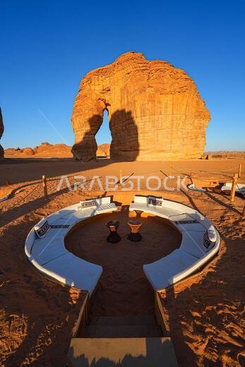 صالة صحراوية فاخرة عند سفح جبل الفيل (صخرة الفيل) عند غروب الشمس في صحراء العلا، المملكة العربية السعودية