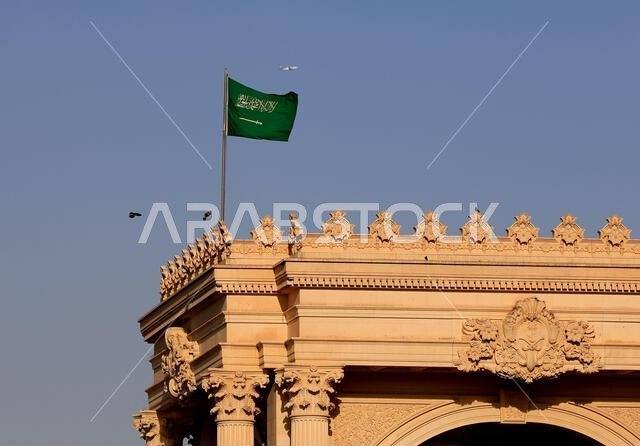 الحياة اليومية في عاصمة المملكة العربية السعودية - الرياض. علم المملكة العربية السعودية يرفرف في الريح.