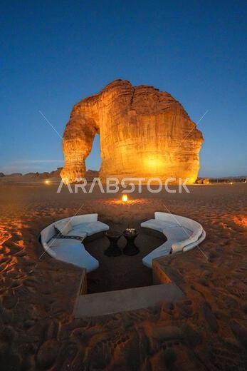 Luxury desert lounge at the foot of Elephant Rock (Jabal Al-Fil) at dusk in the desert of AlUla, Saudi Arabia