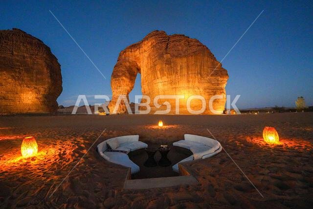 Luxury desert lounge at the foot of Elephant Rock (Jabal Al-Fil) at dusk in the desert of AlUla, Saudi Arabia