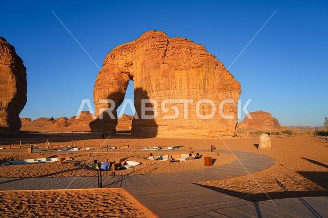 Luxury desert lounge at the foot of Elephant Rock (Jabal Al-Fil) at sunset in the desert of AlUla, Saudi Arabia