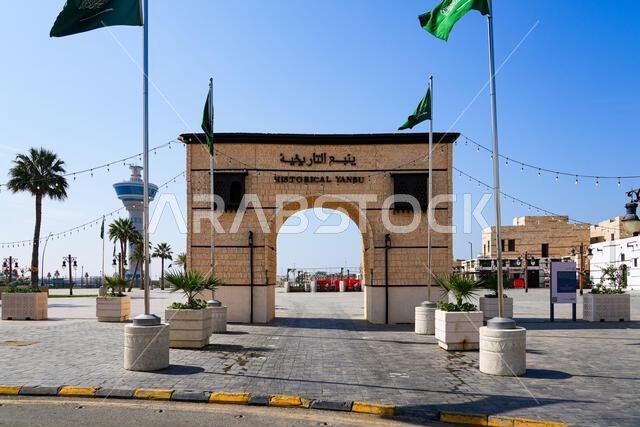 The stone gateway entrance to the Historical Yanbu district with Saudi flags