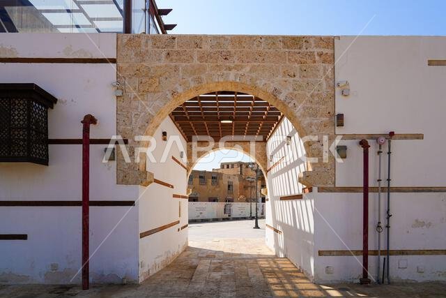 Traditional stone archway and wooden pergola in the historic Al-Balad district of Yanbu, Saudi Arabia
