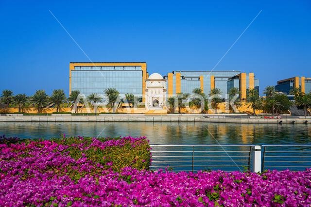 تباين العمارة التقليدية للأجنحة مع المباني الزجاجية الحديثة في مدينة الملك عبد الله الاقتصادية (KAEC)، المملكة العربية السعودية