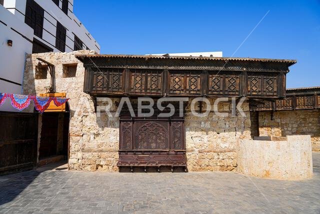 روشان ومشربية خشبية تقليدية على جدار من الحجر المرجاني في ينبع، المملكة العربية السعودية