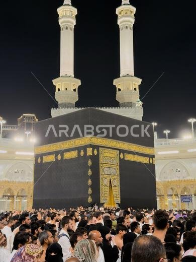 Pilgrims praying around the Kaaba in Mecca at night during pilgrimage in the Grand Mosque