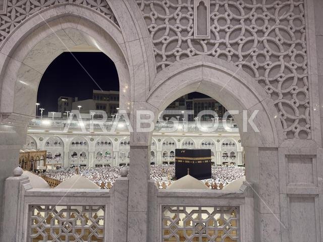Night view of the Kaaba in Mecca at Masjid al-Haram with thousands of pilgrims praying