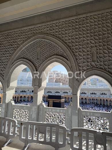 منظر للكعبة والحجاج في المسجد الحرام محاطين بأقواس رخامية مزخرفة في مكة المكرمة