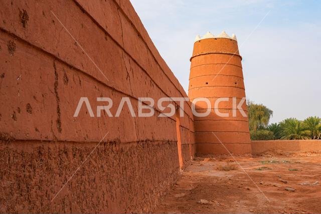 Traditional Najdi mud brick watchtower with white crenelations in Shaqra, a historical desert village in Saudi Arabia