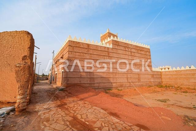 Traditional Najdi mud brick house with white crenelations in Shaqra, a historical desert village in the Washm region of Saudi Arabia