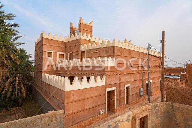 Traditional Najdi mud brick house with white crenelations in Shaqra, a historical desert village in the Washm region of Saudi Arabia