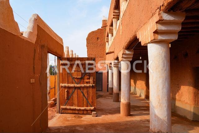 Traditional Najdi courtyard with white columns and adobe walls in Shaqra, Saudi Arabia