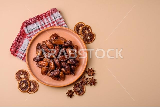 Dried dates on a ceramic plate for Ramadan or Iftar. Dried dates as a food background for your design