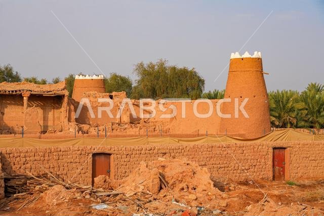 Traditional Najdi mud brick watchtower with white crenelations in Shaqra, a historical desert village in Saudi Arabia