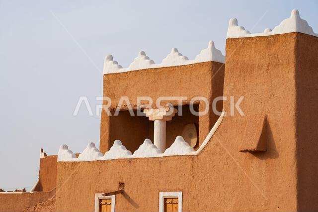 Traditional Najdi mud brick fortification with white crenelations in Shaqra, Saudi Arabia