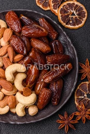 تمر مجفف على طبق خزفي لرمضان أو الإفطار. التمر المجفف كخلفية طعام لتصميمك تمر مجفف على طبق خزفي لرمضان أو الإفطار. التمر المجفف كخلفية طعام لتصميمك