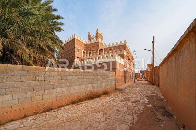 Traditional Najdi mud brick house with white crenelations in Shaqra, a historical desert village in the Washm region of Saudi Arabia