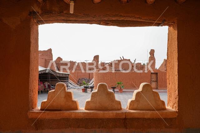 Framed view of a traditional courtyard and ruins in the historic village of Shaqra, Saudi Arabia