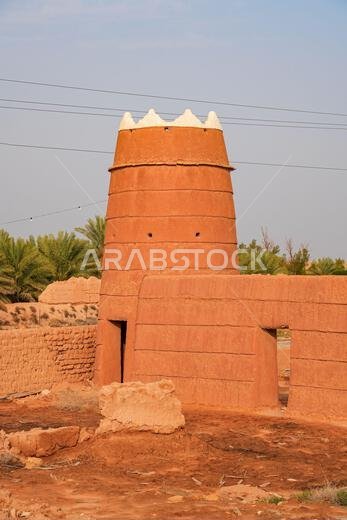 Traditional Najdi mud brick watchtower with white crenelations in Shaqra, a historical desert village in Saudi Arabia