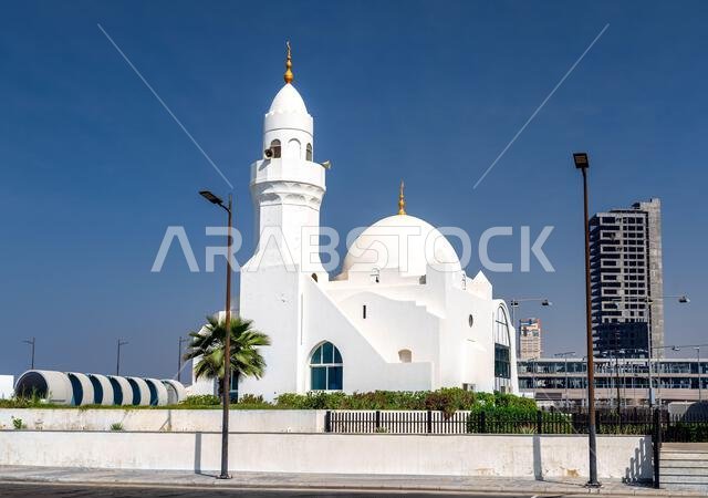 مسجد أبيض أنيق يتميز بقبة ومئذنة تقليديتين تحت سماء زرقاء صافية على كورنيش جدة في المملكة العربية السعودية