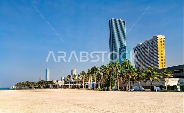 ناطحات سحاب حديثة وأشجار نخيل وارفة على طول واجهة جدة الرملية تحت سماء زرقاء صافية في المملكة العربية السعودية