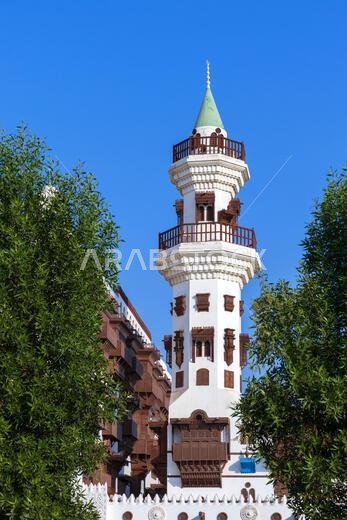 A minaret in traditional Hijazi-style with wooden balconies and lattice windows at the Al Tayebat International City Museum in Jeddah, Saudi Arabia