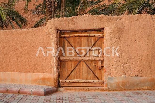 Traditional Najdi wooden door and mud brick wall in the historic village of Shaqra, Saudi Arabia