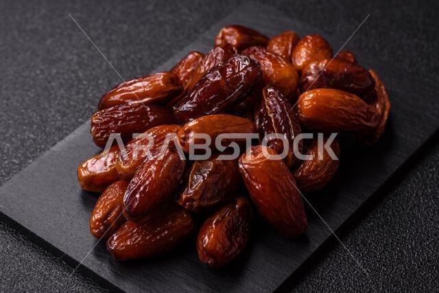 تمر مجفف على طبق خزفي لرمضان أو الإفطار. التمر المجفف كخلفية طعام لتصميمك تمر مجفف على طبق خزفي لرمضان أو الإفطار. التمر المجفف كخلفية طعام لتصميمك