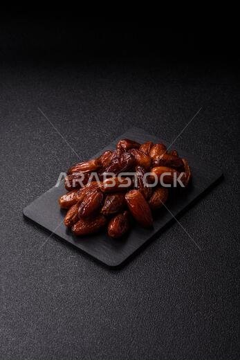Dried dates on a ceramic plate for Ramadan or Iftar. Dried dates as a food background for your design